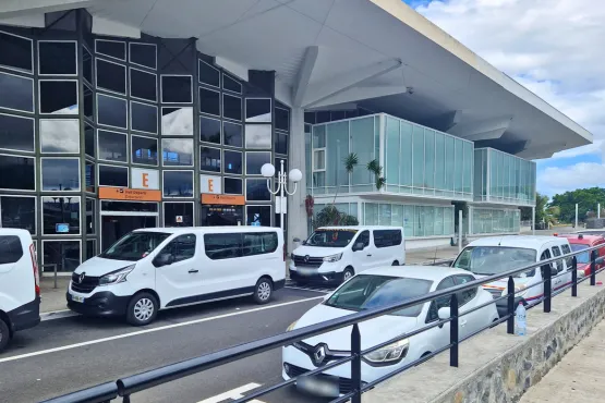 van taxi la reunion stationnant devant entree aeroport roland garros pour transfert